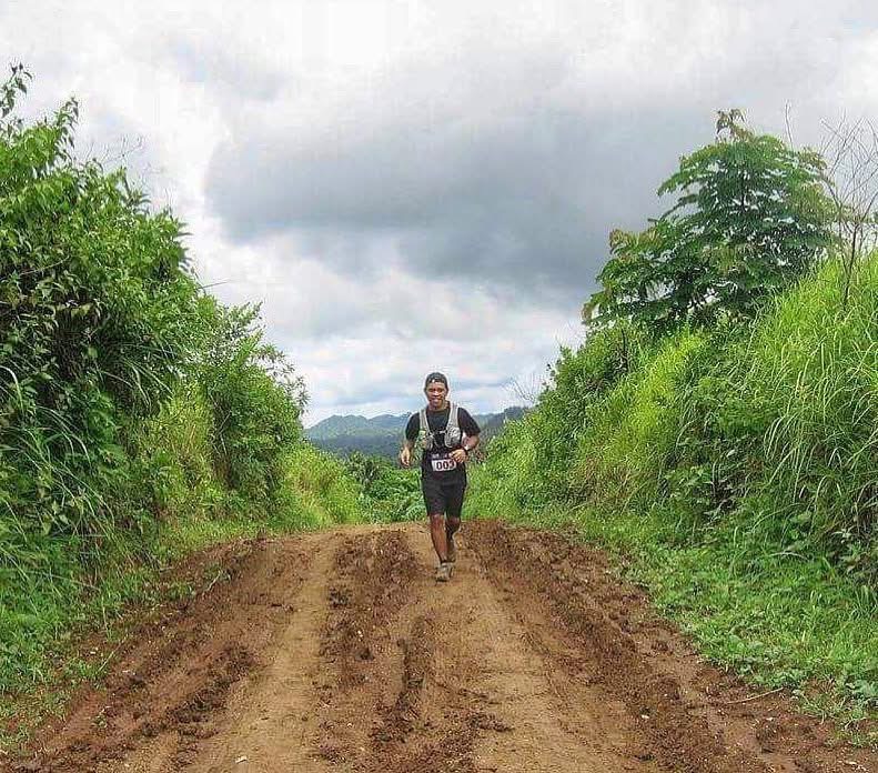 male trail runner running up mount batulao during tnf100 2008